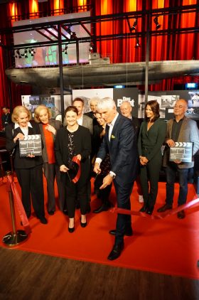 Digitalministerin Judith Gerlach, MdL, und Achim Rohnke, Geschäftsführer der Bavaria Film GmbH, durchschneiden bei der feierlichen Eröffnung des Filmstadt Ateliers das rote Band.