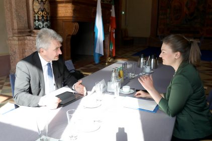Digitalministerin Judith Gerlach sitzt Prof. Pinkwart an einem Tisch gegenüber, beide unterhalten sich.
