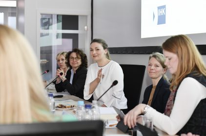 Digitalministerin Judith Gerlach, MdL, im Gespräch mit den Teilnehmerinnen des IHK-Arbeitskreises Frauen. Gerlach sitzt an einem Besprechungstisch und ist umringt von Zuhörerinnen.
