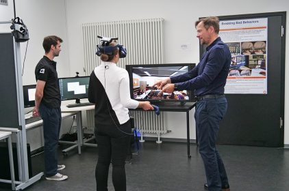 Prof. Dr. Marc Erich Latoschik (rechts) und ein Mitarbeiter zeigen Digitalministerin Judith Gerlach, MdL (Mitte), das Projekt "Breaking Bad Behaviors". © Uni Würzburg