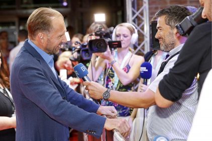 Der britische Schauspieler Ralph Fiennes wird auf dem roten Teppich von zahlreichen Kamerateams in Empfang genommen. © Filmfest München / Kurt Krieger