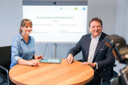 Die Digitalministerin, Judith Gerlach, unterschreibt mit dem Präsidenten der IHK für München und Oberbayern, Dr. Eberhard Sasse, das Dokument zur gemeinsamen Blockchain-Partnerschaft.