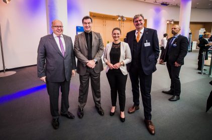 Bundeswirtschaftsminister Peter Altmaier, MdB, Ministerpraesident Dr. Markus Soeder, MdL, Digitalministerin Judith Gerlach, MdL, und der Geschaeftsfuehrer der NuernbergMesse Peter Ottmann stehen in einem Konferenzraum nebeneinander