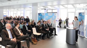 Digitalministerin Judith Gerlach, MdL, steht am Rednerpult bei dem Neujahrsempfang von M-net und haelt eine Rede. Links von ihr sind zahlreiche Gäste zu sehen.
