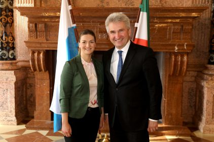 Digitalministerin Judith Gerlach, MdL, und Prof. Dr. Andreas Pinkwart, Wirtschafts- und Digitalminister des Landes Nordrhein-Westfalen im Anschluss. Beide stehen vor einem steinernen Kamin und den Fahnen beider Länder. an die gemeinsame Kabin