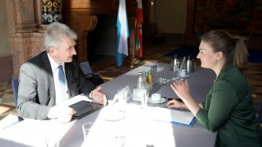 Digitalministerin Judith Gerlach sitzt Prof. Pinkwart an einem Tisch gegenüber, beide unterhalten sich.