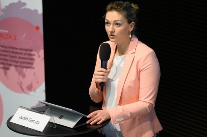 Digitalministerin Judith Gerlach, MdL steht bei ihrer Keynote an einem Rednerpult und hält ein Mikrofon in der Hand. Auf dem Pult steht ihr Namensschild.