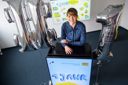 Digitalministerin Gerlach mit Luftballons in der Form Hashtag 1