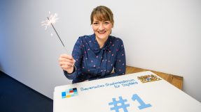 Digitalministerin Gerlach mit Wunderkerze und Geburtstagstorte