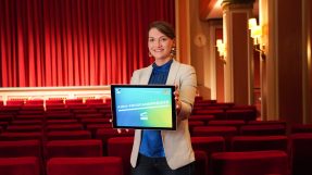 Digitalministerin Gerlach hält ein Tablet mit dem Text: Kino-Programmprämien