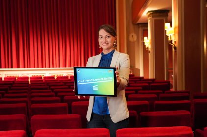 Digitalministerin Gerlach hält ein Tablet mit dem Text: Kino-Programmprämien