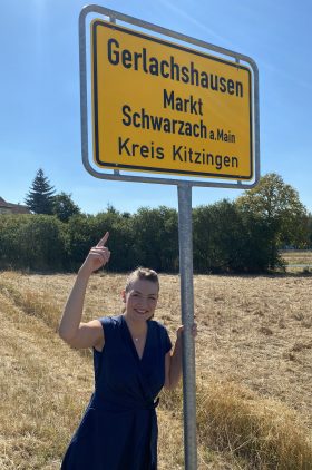 Foto von Digitalministerin Gerlach vor dem Ortsschild Gerlachshausen