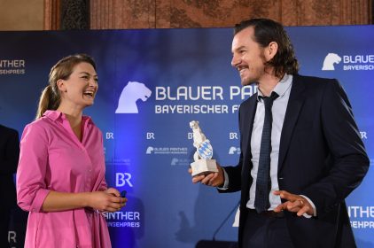 Digitalministerin Judith Gerlach mit Preisträger Felix Klare Hand hält. Beide lachen.