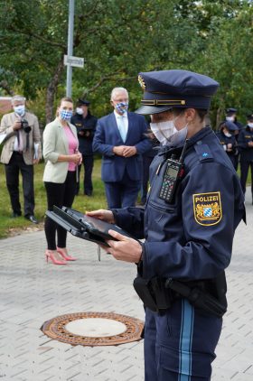 Eine Polizistin schaut auf einen Tablet-Computer