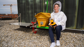 Digitalministerin Gerlach neben einem Bienenstock auf dem Dach