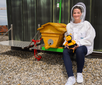 Digitalministerin Gerlach neben einem Bienenstock auf dem Dach
