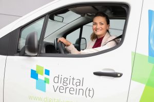 Digitalministerin Judith Gerlach sitzt in einem Kleinbus mit der Aufschrift digital verein(t)