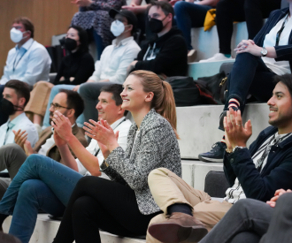 Digitalministerin Gerlach sitzt im Publikum und klascht.