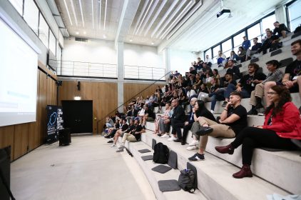 Das Auditorium im Munich Urban Colab ist bei der Abschlussveranstaltung zu Batch #2 der Digitalschmiede Bayern gut gefüllt.