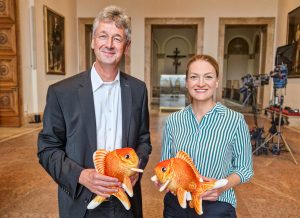 Kultusminister Piazolo und Digitalministerin Gerlach halten Stofftiergoldfische