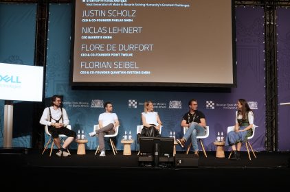 Moderatorin mit vier Panelisten bei einer Diskussionsrunde.