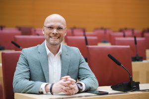 Staatsminister Dr. Fabian Mehring lachend im Bayerischen Landtag