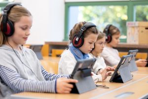 Kinder mit Ipads und Kopfhörern