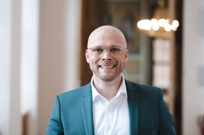 Staatsminister Dr. Fabian Mehring lacht in Kamera - Portraitaufnahme.